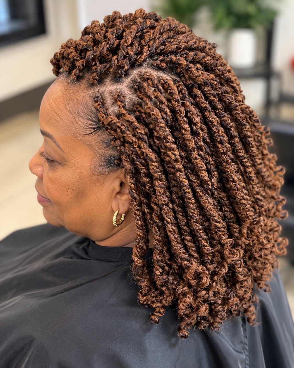 Shoulder-length kinky twists in warm copper brown, shown in side profile